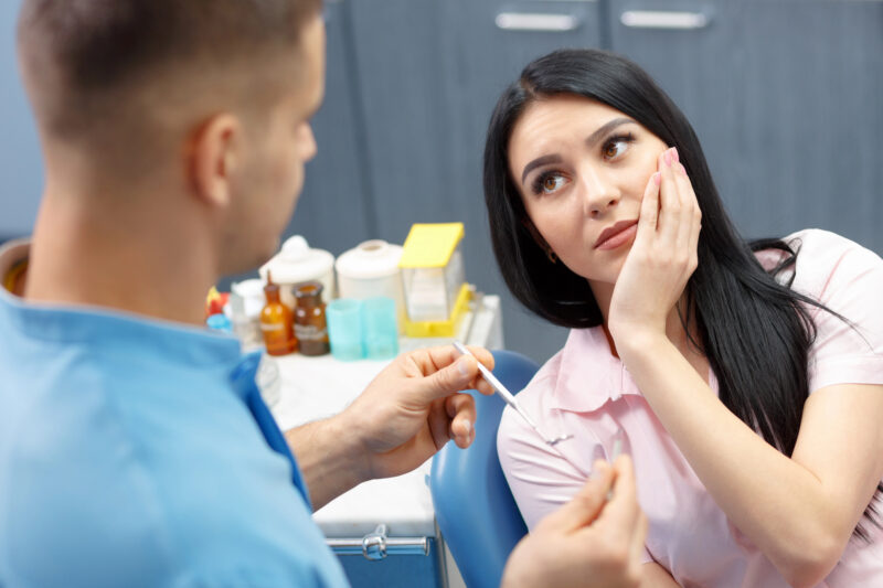 woman having a toothache and probably needs a root canal