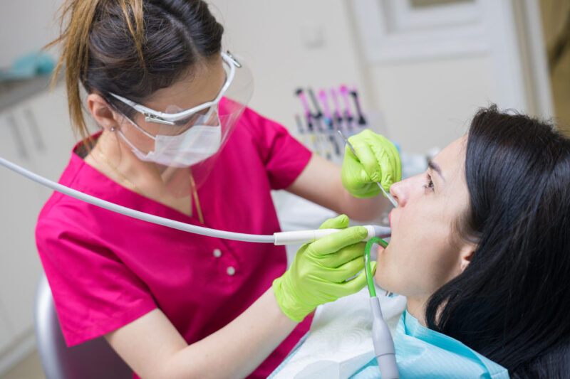 dentist cleaning woman's teeth, professional dental cleaning