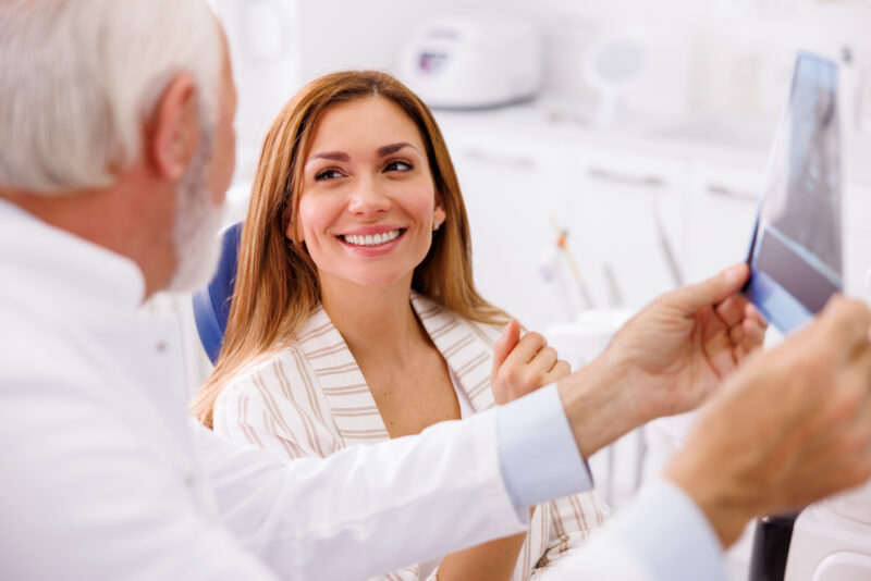 woman at the dentist smiling and is happy with her all on x dental implants