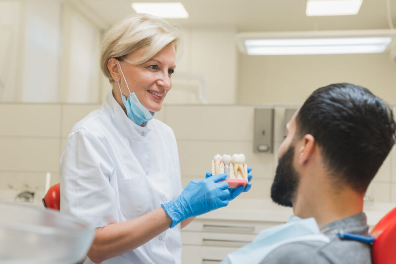 dentist showing patient all on x and all on 4 dental implants differences