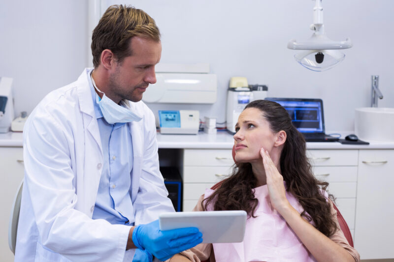 woman in pain and has gone to the dentist for an emergency appointment