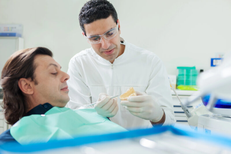 dentist showing patient what a full arch dental implant looks like